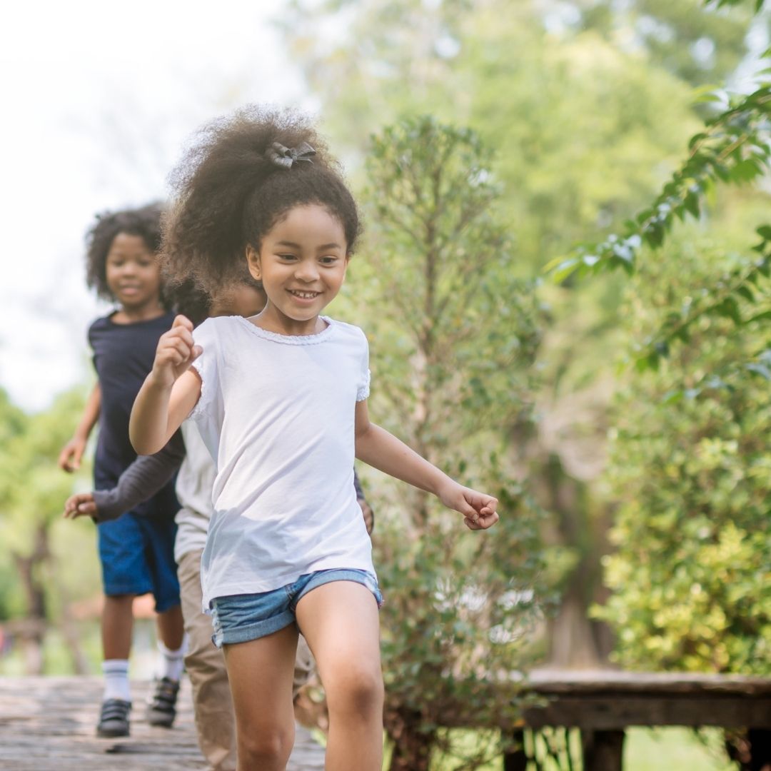 Happy children running on a wooden bridge